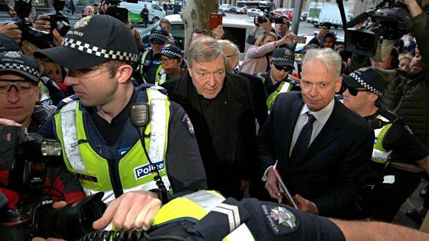 Cardinal George Pell makes his way through the throng of media, with lawyer Paul Galbally by his side. Photo: Jason South