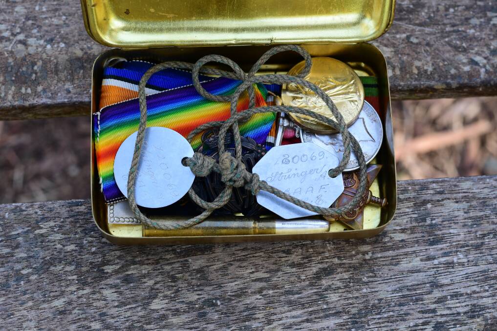 Private George Stringer's identification tags and medals in the same tin in which they have been stored for years. Picture: NONI HYETT