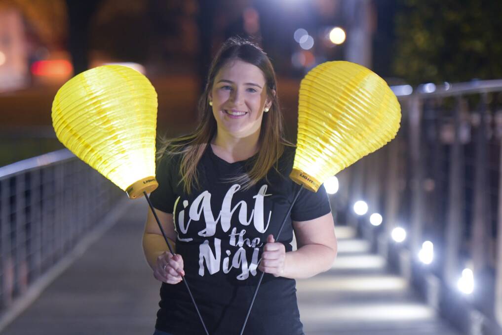 The gold lanterns in Ashlee Browell's hands symbolise remembering loved ones lost to blood cancer. Picture: NONI HYETT