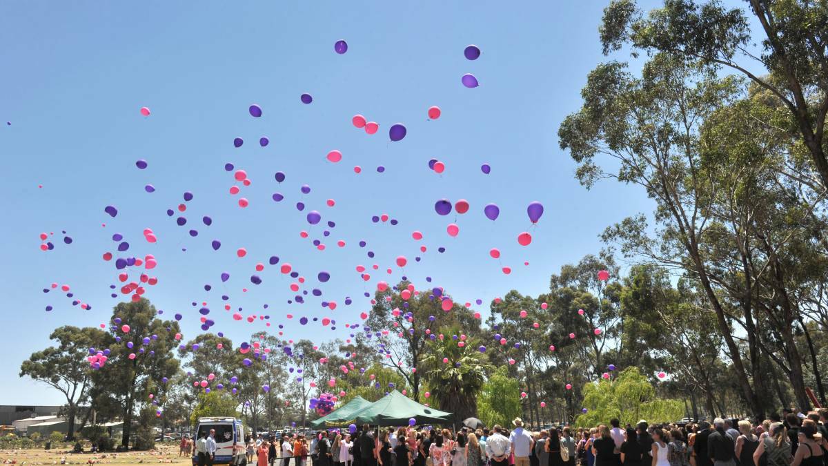 REMEMBERING: Pink and purple balloons are released at Patiya May Schreiber's funeral - her favourite colours.