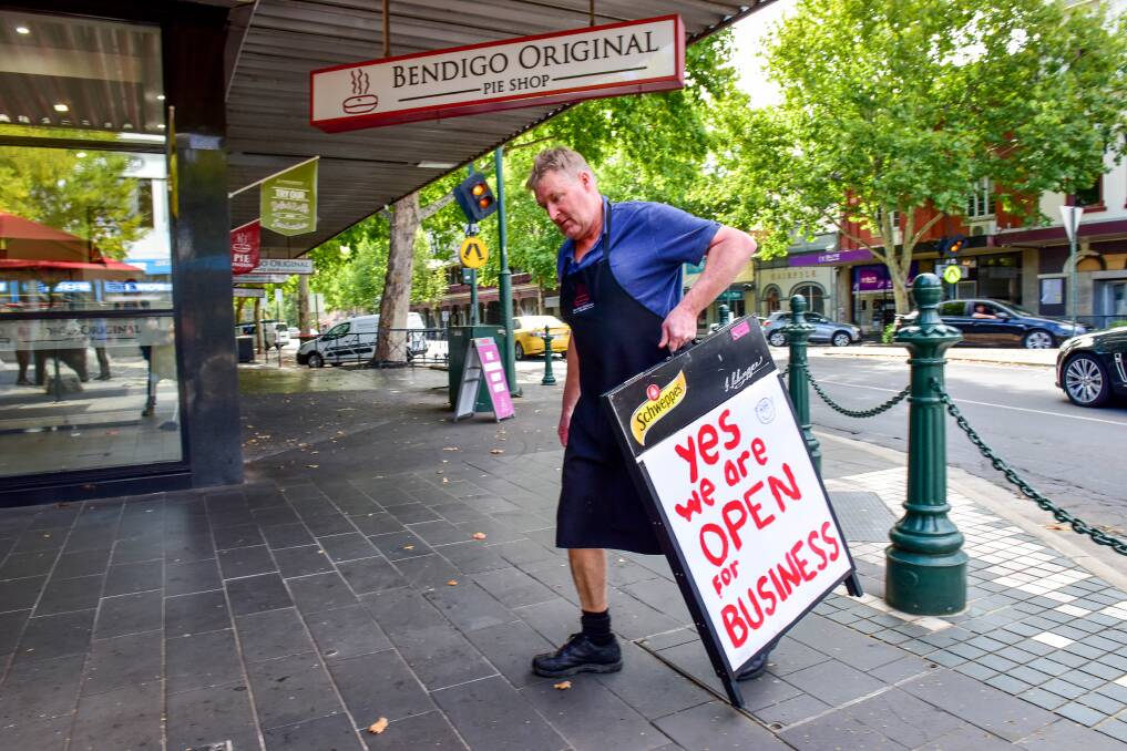 SIGN OF THE TIMES: Grant Findlay packs down a sign out the front of the business he and wife Julie Findlay own. Tomorrow will likely be the Bendigo Original Pie Shop's last day of trade until the virus crisis ends. Picture: BRENDAN McCARTHY