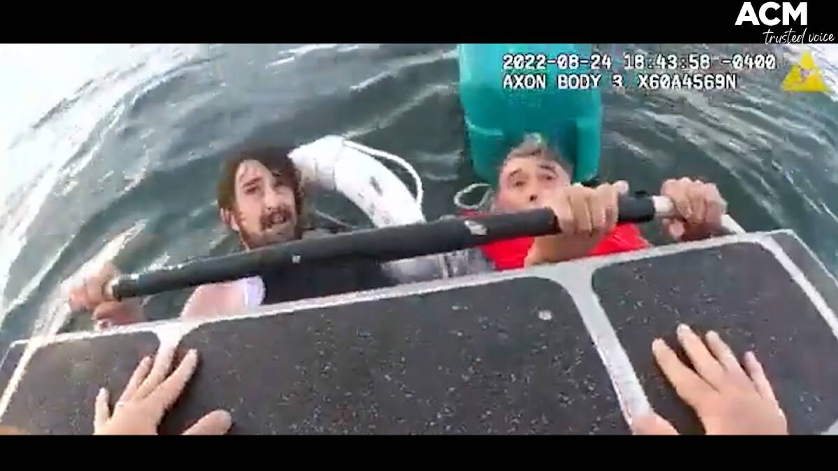 Footage released by the Boston Police Department shows the father and son clinging onto an esky in choppy waters before rescuers arrive. Picture supplied