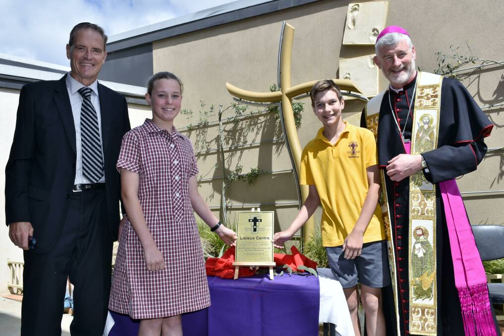 Principal Matt Mann and Bishop Shane Mackinlay with St Therese's Primary School Grade 6 students Hayley Couch and Zane Connick at the official blessing of the Lisieux Centre, while above right, Liam Hubble helps the Bishop. 