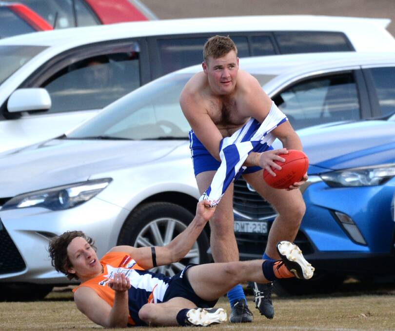 GOING NOWHERE: Mitiamo's Nick Farley has his jumper ripped off in a tackle by Maiden Gully YCW's Nick Waterson on Saturday.