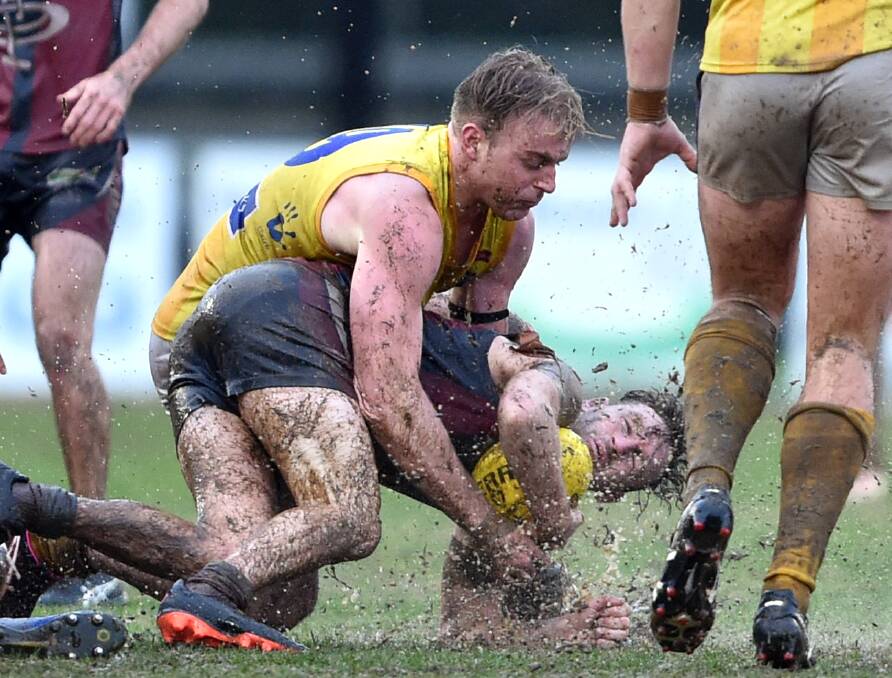 WRAPPED UP: Strathfieldsaye's Hugh Robertson lays a tackle on Sandhurst's Nick Stagg. Just eight goals were kicked in the match between the Storm and Dragons.