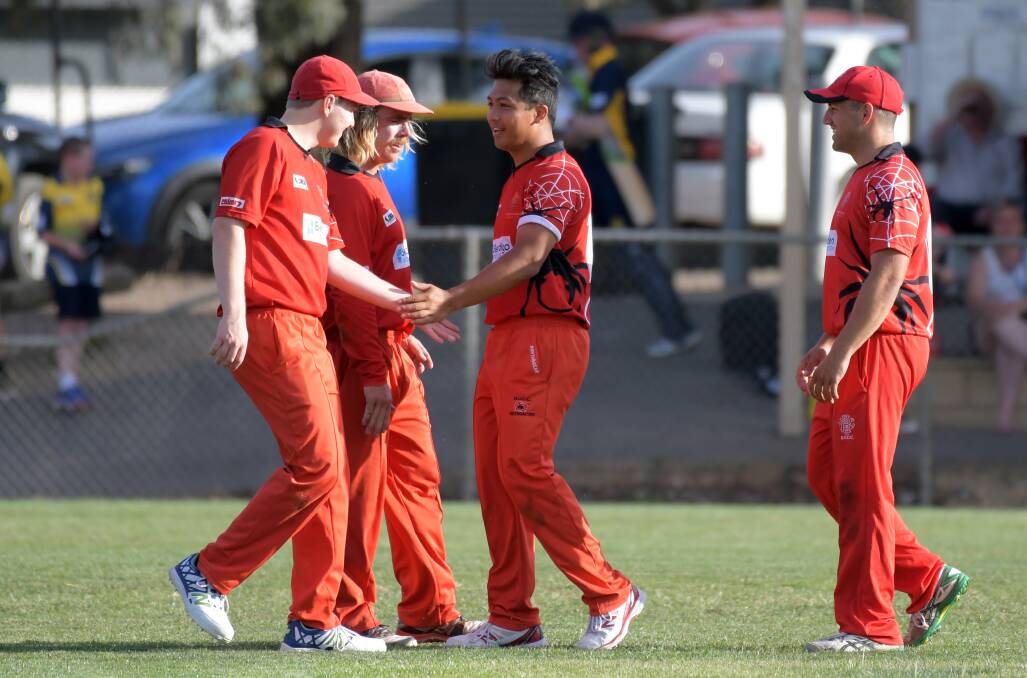 ALL SMILES: Bendigo United players get around Miggy Podsoky after he claimed the wicket of Bendigo's Kyle Humphrys.