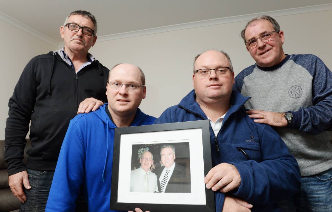 REMEMBERING: Chris Cole, Jason Cole, Shayne Cole and Tony Cole with a photo of the late Peter Cole and Eddie McGuire. Picture: DARREN HOWE