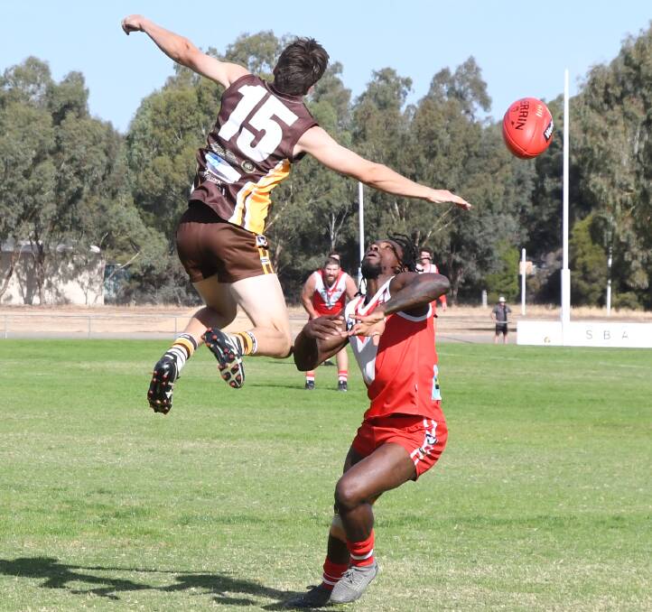 BALL IN DISPUTE: Huntly defender Steve Kairn and Elmore forward Romain Grenville. Grenville kicked four goals in the Bloods' tight win over the Hawks in round two of the HDFNL season on Saturday. Pictures: KIERAN ILES