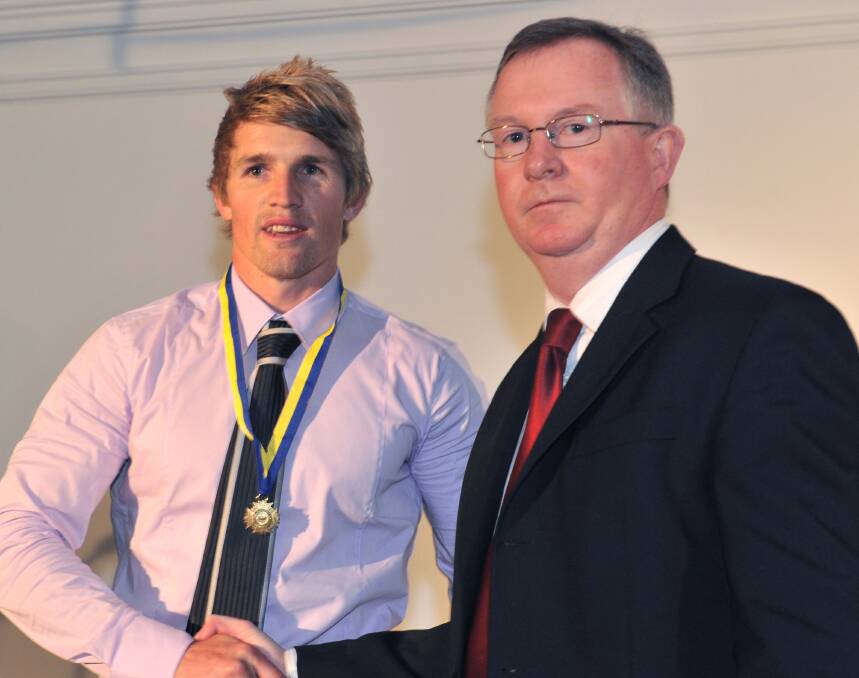 MAGPIE MEDAL: BFNL chairman Paul Byrne congratulates Castlemaine's Wayne Schultz after his win in the 2011 Michelsen Medal. Schultz starred in a Magpies' team that won just two games that year.