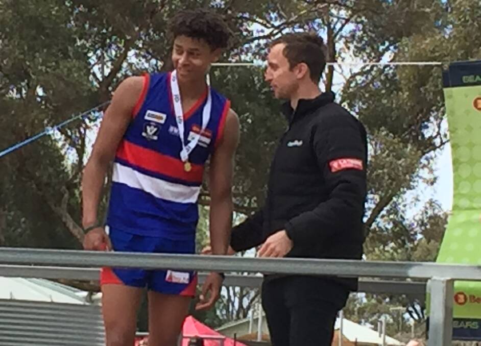 Pyramid Hill's Kai Daniels receives the best on ground medal from AFL Central Victoria's Jake McLean.