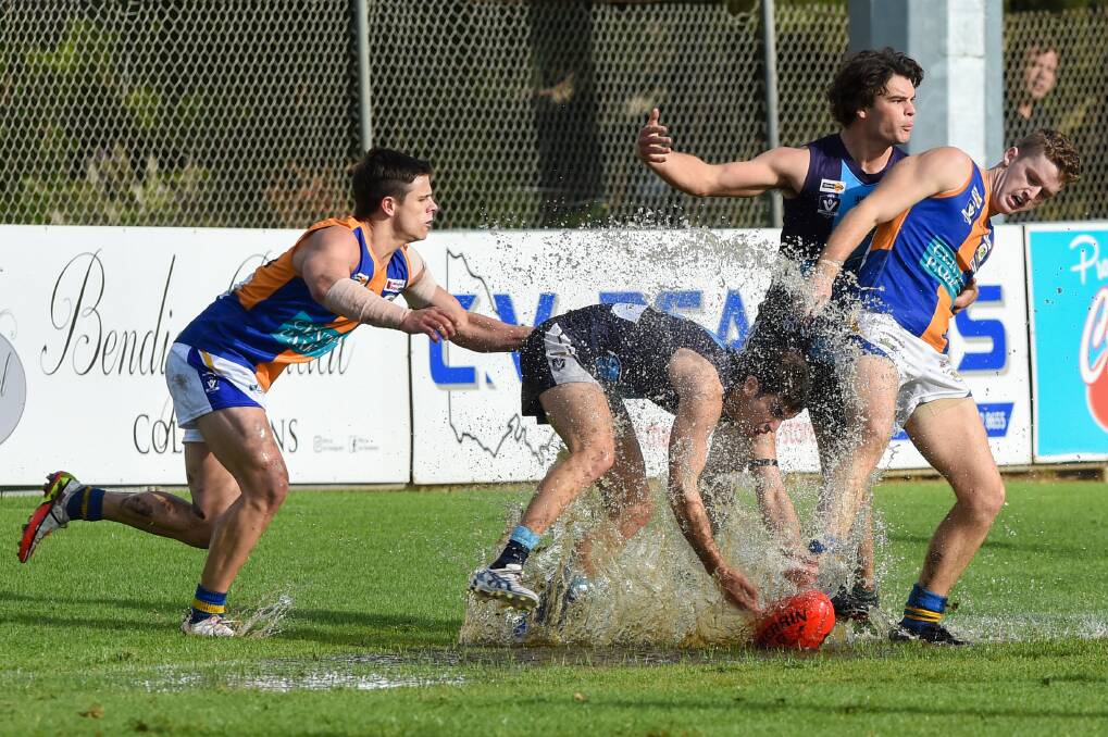 TOUGH SLOG: It was wet weather football at Canterbury Park on Saturday between Eaglehawk and Golden Square. The Bulldogs won by 47 points. Picture: DARREN HOWE