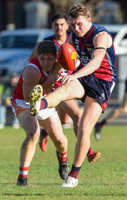 ENTHRALLING CONTEST: Sandhurst's Cobi Maxted kicks under pressure from South Bendigo's Kaiden Antonowicz at the QEO on Saturday. Picture: DARREN HOWE