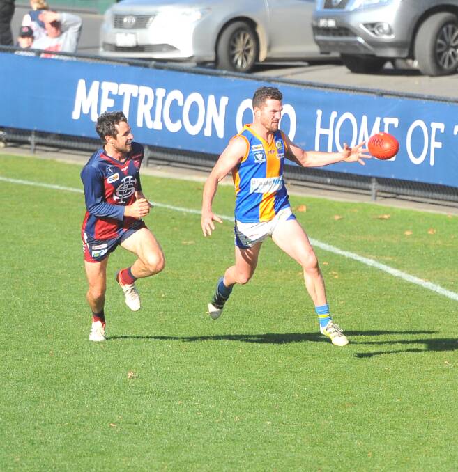 BEST ON GROUND: Golden Square's Travis Baird leads Sandhurst's Jon Coghlan to the ball. Baird kicked six goals in the Bulldogs' win on Saturday. Picture: LUKE WEST