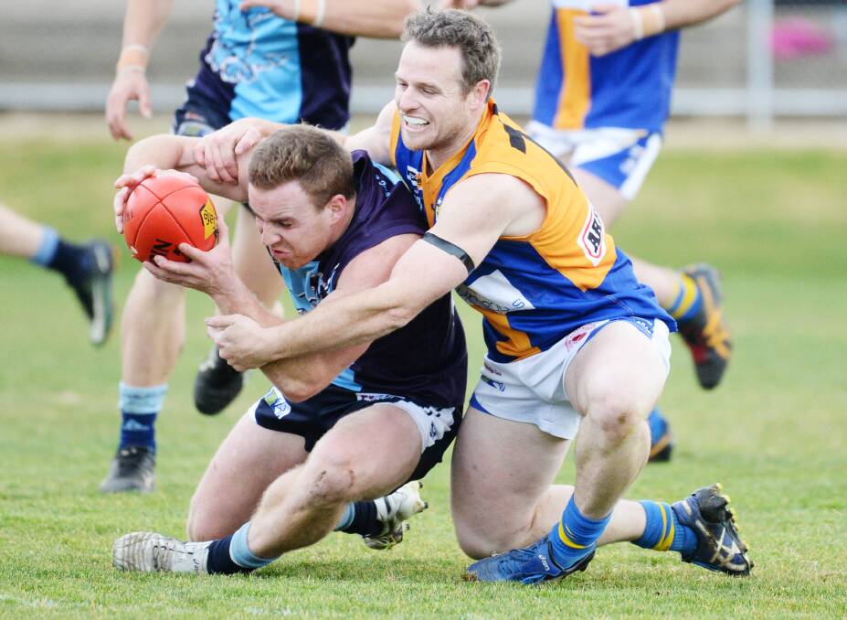 CONTESTED BALL: Golden Square's Dale Lowry lays a tackle on Eaglehawk's Ben McPhee during Saturday's match at Canterbury Park. The Hawks were victors by 21 points, while the Bulldogs dropped out of the top three. Pictures: DARREN HOWE
