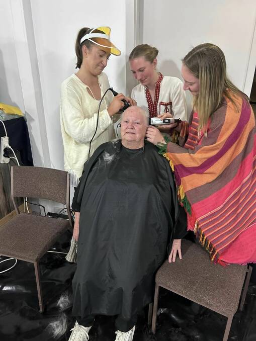 Granddaughters Jordann, Kaitlin and Imogen Broad shave Glenys Broad's head last Saturday night. Picture by Pyramid Hill FNC