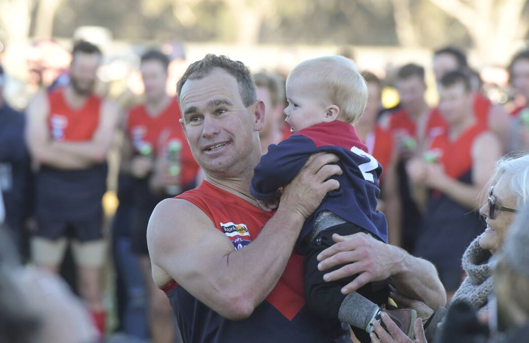 DEMON DELIGHT: Corey Jones with son Jack after winning a premiership with home club Wycheproof-Narraport in the North Central league in 2018.