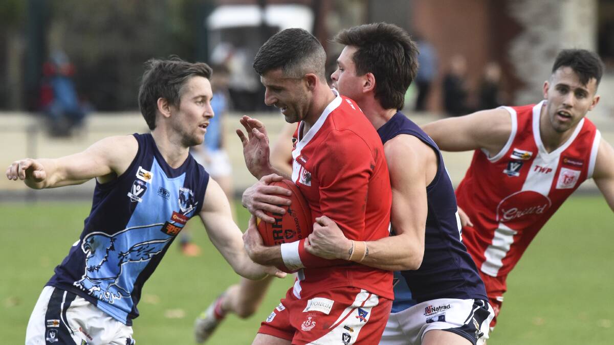 GOTCHA: South Bendigo coach Nathan Horbury is wrapped up in a tackle by Eaglehawk's Zane Carter at the QEO last Saturday. After trailing by 26 points during the second quarter the Bloods won by 22 points. Pictures: DARREN HOWE
