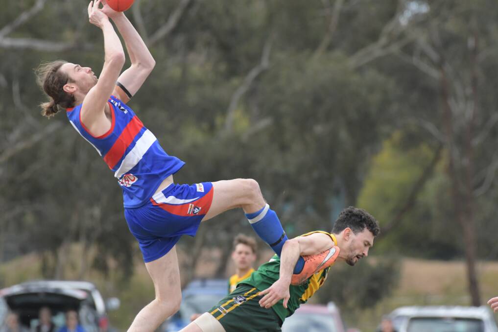 STRONG GRAB: North Bendigo ruckman Troy Kelm takes a soaring mark over the top of Colbinabbin's Michael Battista on Saturday. The Bulldogs kicked 7.7 to 1.1 in the final term to win by 39 points. Pictures: NONI HYETT