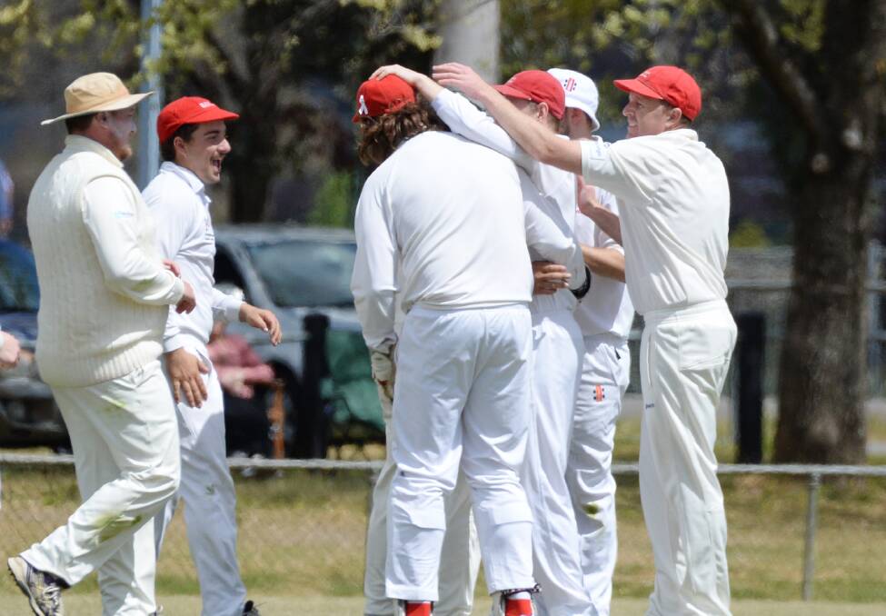 WEB OF REDBACKS: Bendigo United players celebrate a wicket in their round two game against Sandhurst, which they lost by one run.