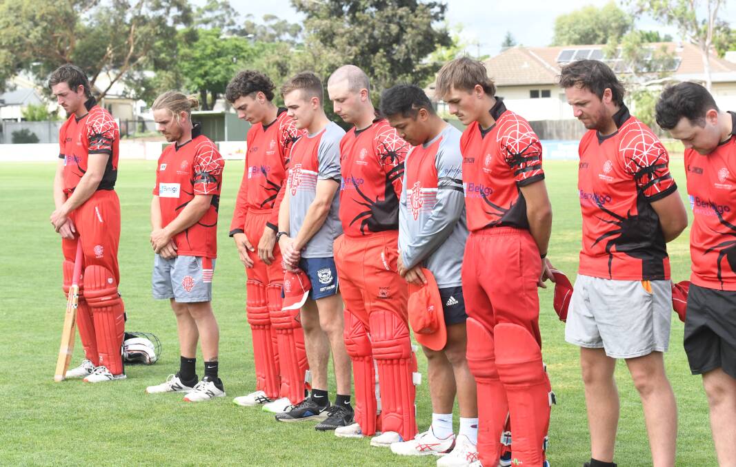 Bendigo United players observe a minute silence.