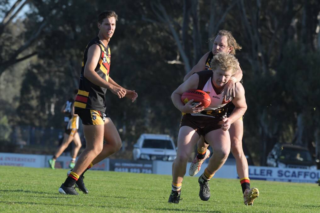Huntly's Harry Whittle is tackled by Leitchville-Gunbower's Hoby Bussey. Picture: NONI HYETT