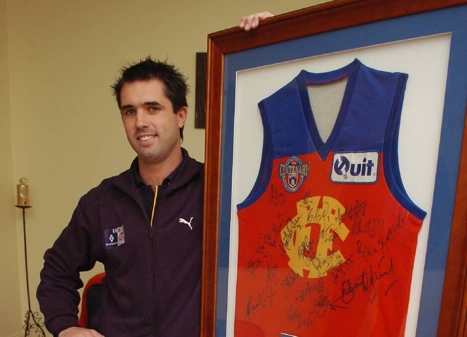 MEMORIES: Rowan Warfe pictured in 2006 with a framed Fitzroy jumper. Warfe played 26 AFL games for Fitzroy, including the club's final match against Fremantle in 1996 before merging with Brisbane.