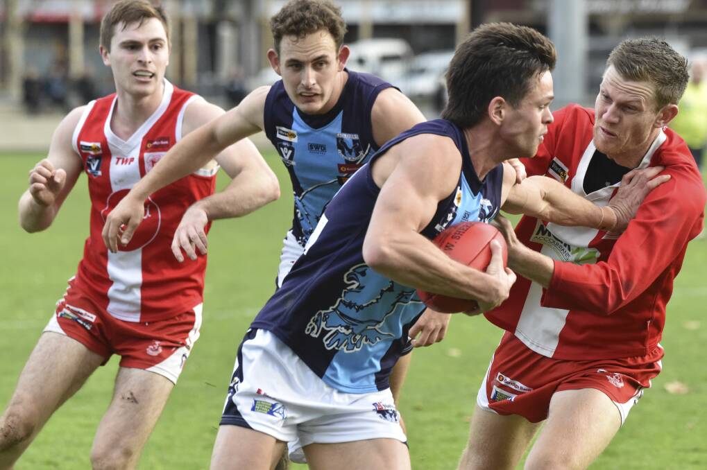 FEND OFF: Eaglehawk's Zane Carter tries to avoid a tackle from South Bendigo's Zac Hare at the QEO on Saturday. The Bloods won by 22 points to climb back into the top five. More pictures at www.bendigoadvertiser.com.au. Picture: NONI HYETT