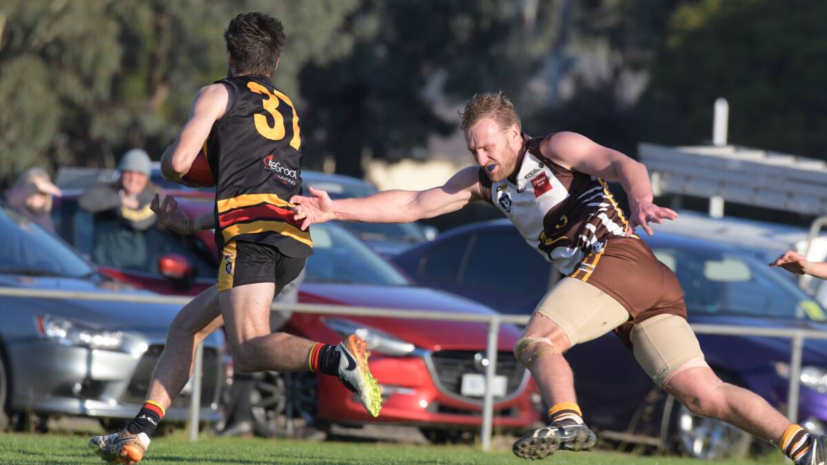 EVASIVE: Leitchville-Gunbower's Hugh McGillivray eludes Huntly's Stacy Fiske on Saturday. The Bombers belted the Hawks by 124 points. Picture: NONI HYETT