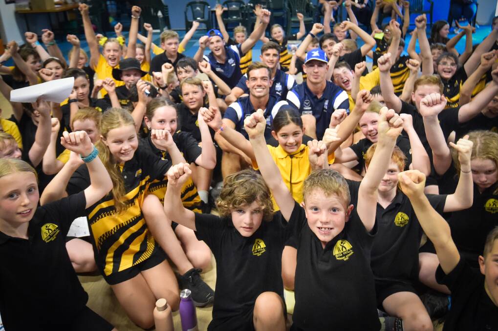 North Melbourne players Jy Simpkin, Harry Sheezel, Will Dawson and Tom Powell with students from Big Hill Primary School on Monday. Picture by Darren Howe
