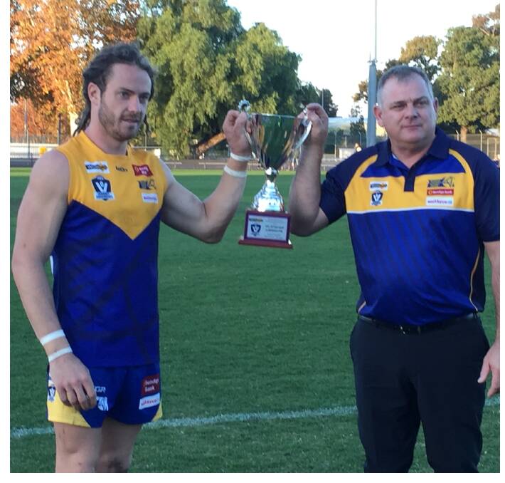 BLUE AND GOLD PASSION: Bendigo captain Jack Geary and coach Darryl Wilson with the trophy for beating Outer East. Picture: LUKE WEST
