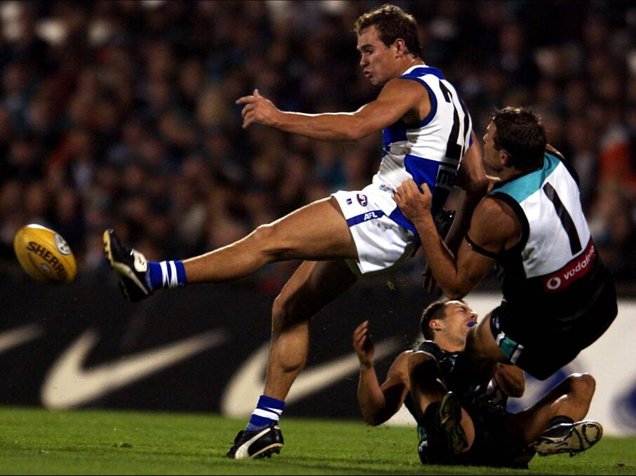 CONTEST: Corey Jones gets a kick away for North Melbourne in a game against Port Adelaide in the opening round of 2002. The Kangaroos won by 10 points this night at Football Park. Picture: GETTY IMAGES