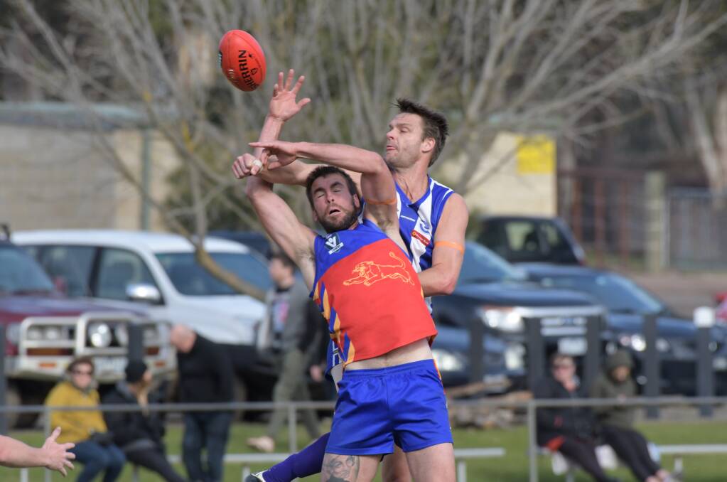 BIG MEN FLY: Marong's Justin Hynes and Mitiamo's Michael I'Anson, who kicked three goals, compete in a ruck duel on Saturday. The Superoos were big winners by 92 points to keep hold of their top five position. Pictures: NONI HYETT