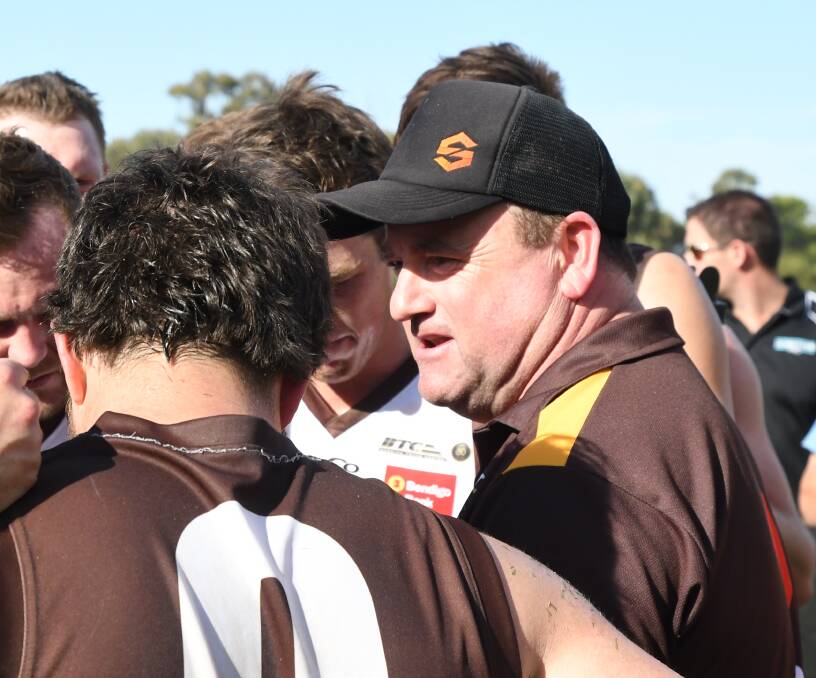 WORDS OF WISDOM: Huntly coach Denis Grinton speaks to his players at quarter-time against Elmore. The Hawks were a goal up at the first change.