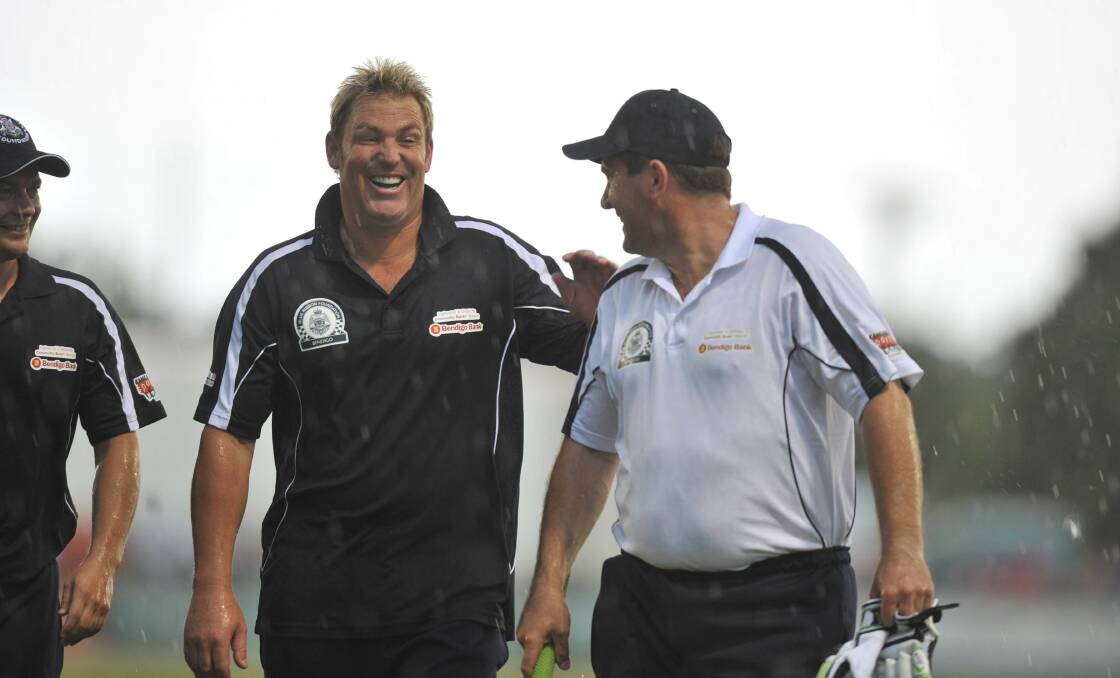 RAINED OUT: Shane Warne and Mark Taylor leave the field after the John Forbes Tribute Match was washed out halfway through.