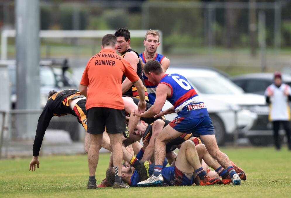 NO LOVE LOST: North Bendigo and Leitchville-Gunbower players tussle in the wet at Atkins Street on Saturday. The Bulldogs won by 58 points. Picture: GLENN DANIELS