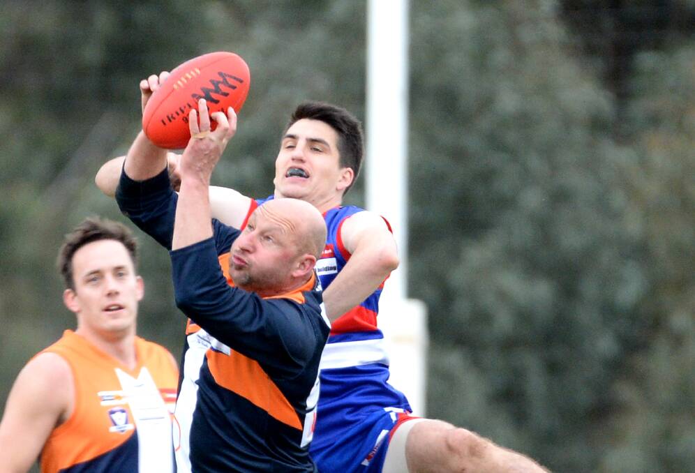 STRONG HANDS: Maiden Gully YCW coach Wayne Mitrovic marks in front of Pyramid Hill defender Dylan Morison. Picture: DARREN HOWE