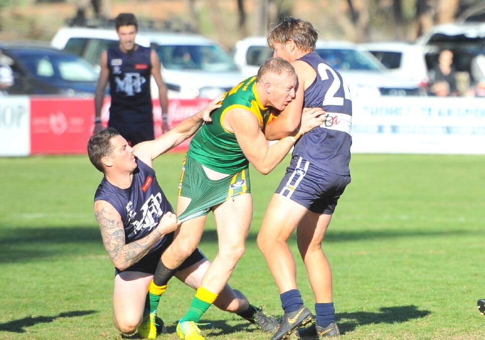 SANDWICHED: Colbinabbin's Daniel Connors under pressure against Mount Pleasant on Saturday. The Grasshoppers were far too good for the Blues by 45 points at Toolleen in the match-up of third v fourth. Pictures: ADAM BOURKE