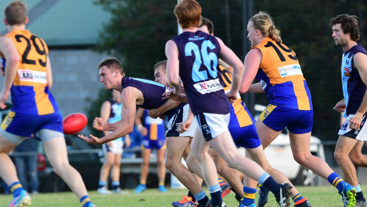 TIGHT TUSSLE: Eaglehawk's Jonty Neaves dishes off a handball during Saturday's win over Golden Square. The Hawks were victors by 19 points. Picture: NONI HYETT