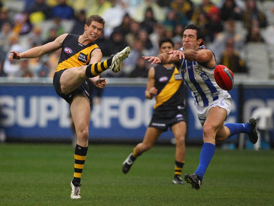 TIGER ON THE PROWL: Andrew Collins gets a kick away against North Melbourne at the MCG in 2010. Picture: GETTY IMAGES