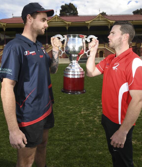 CALM BEFORE THE STORM: Calivil United's Alex Davis and Bridgewater coach Marc Lindsay with the Loddon Valley league's Manley Cup on Friday. Picture: NONI HYETT