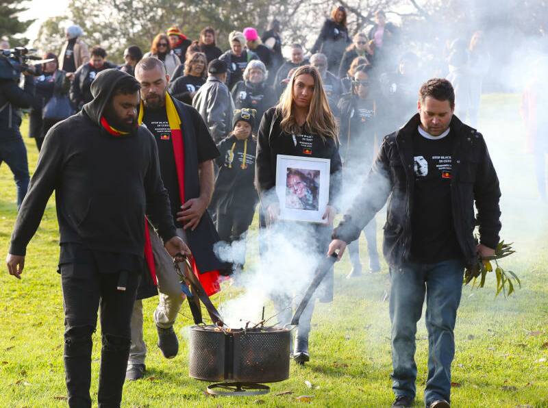 Family members, including Tanya's daughter Apryl Watson (centre), march to the Coroners Court after smoking ceremony in Kings Domain Park.