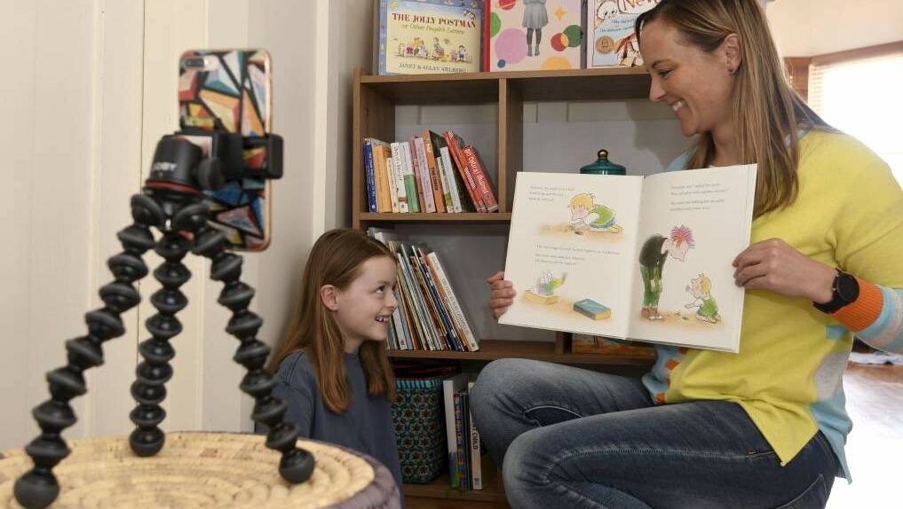 Ballarat Foundation community engagement and communications coordinator Ricci Shephard reads to her eight-year-old daughter Zoe McGreevy. She is hosting online story time for the community every day through Book Week. Photo: Lachlan Bence