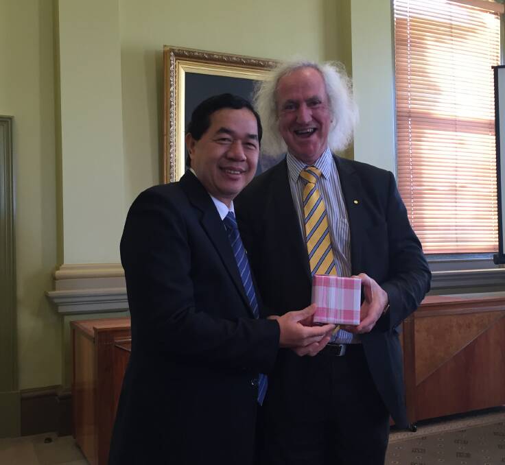 FRIENDLY RELATIONS: Ho Chi Minh City planning and investment director Su Ngoc Anh and Bendigo mayor Rod Fyffe exchange gifts. Picture: JOSEPH HINCHLIFFE