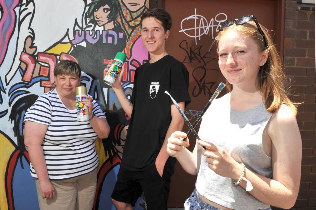 ART vs GRAFFITI: Cobie Normington of Radius Disability Services with project volunteers Tom and Clare Cook in Mitchell Lane. Picture: NONI HYETT
