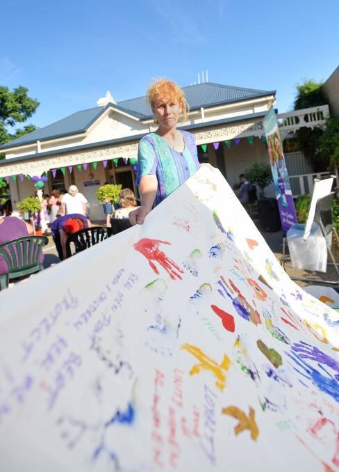 NO MORE VIOLENCE: Carolyn Neilson with a banner made by women who have had lived experience of domestic violence. Picture: DARREN HOWE
