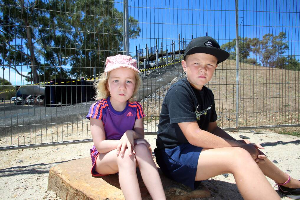 Charlotte Cason (5) and Lachlan Hulls (9) in front of the burnt-down playground. 