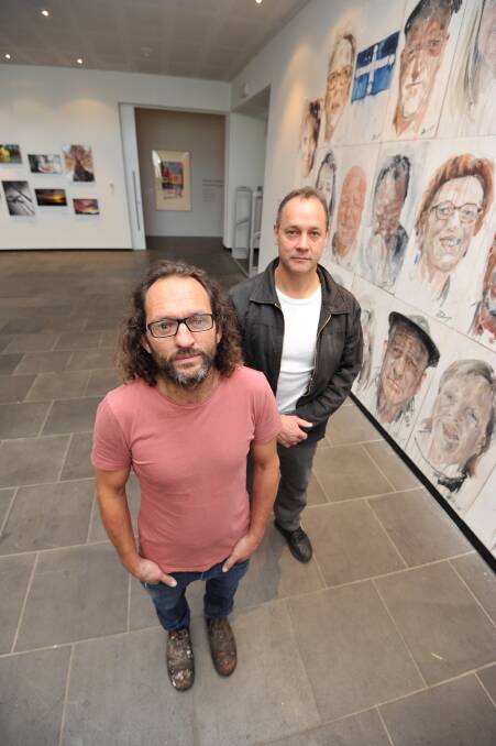 BEHIND THE MASK: Artist Daniel Butterworth and clergy abuse survivor and photographer Peter Blenkiron at the exhibition. Picture: Lachlan Bence