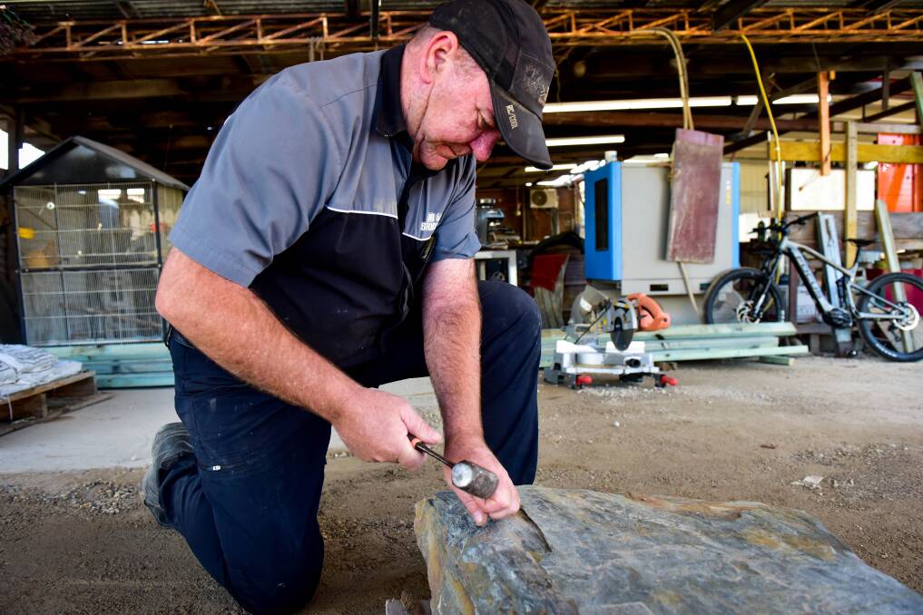 RESTORATION: Mark Blakely hard at work in his Bendigo workshop, where the gravestone found at the Castlemaine cemetery was restored. Picture: BRENDAN McCARTHY