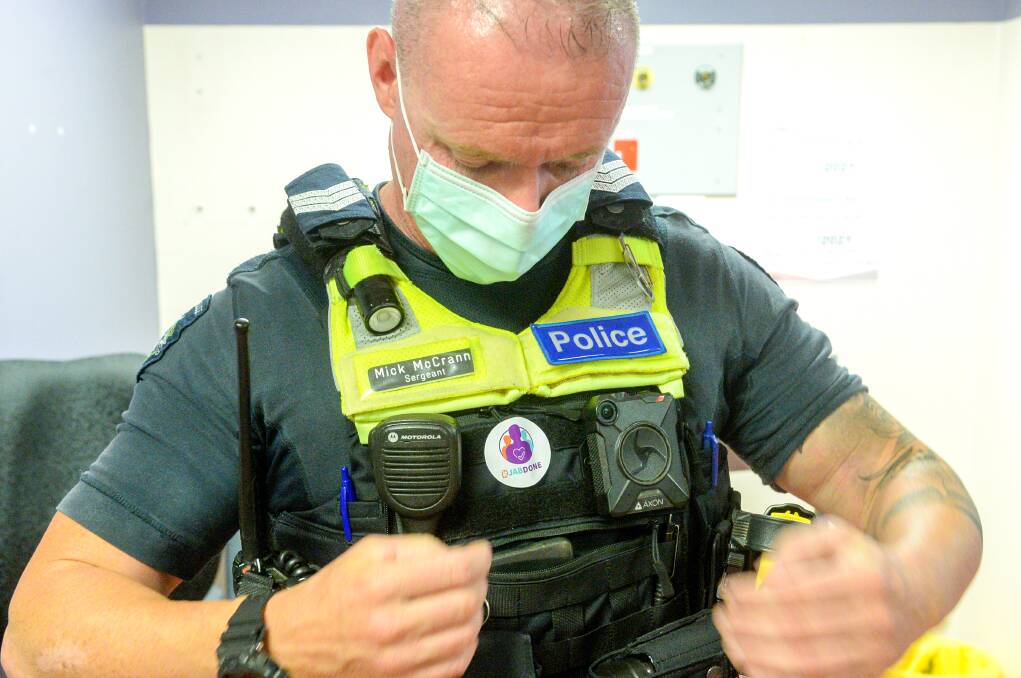 Sergeant Mick McCrann wears a sticker showing he has received a COVID-19 vaccine. Picture: DARREN HOWE