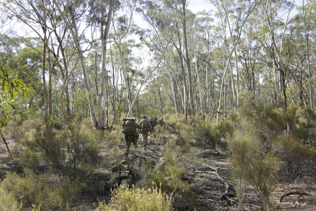 A contingent of Australian and British army reservists traverse the scrub of Puckapunyal Military Area in regional Victoria as part of Exercise Jacka Run. Pictures: Matt Dennien